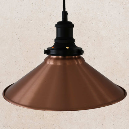 Copper pendant light against a beige textured wall