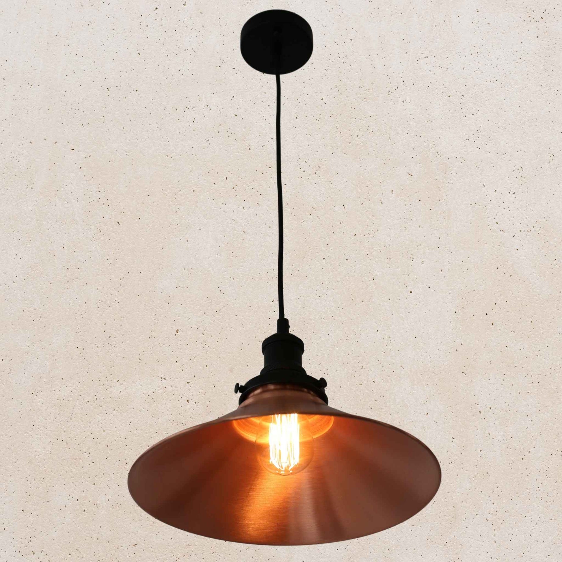 Copper pendant light against a beige textured wall