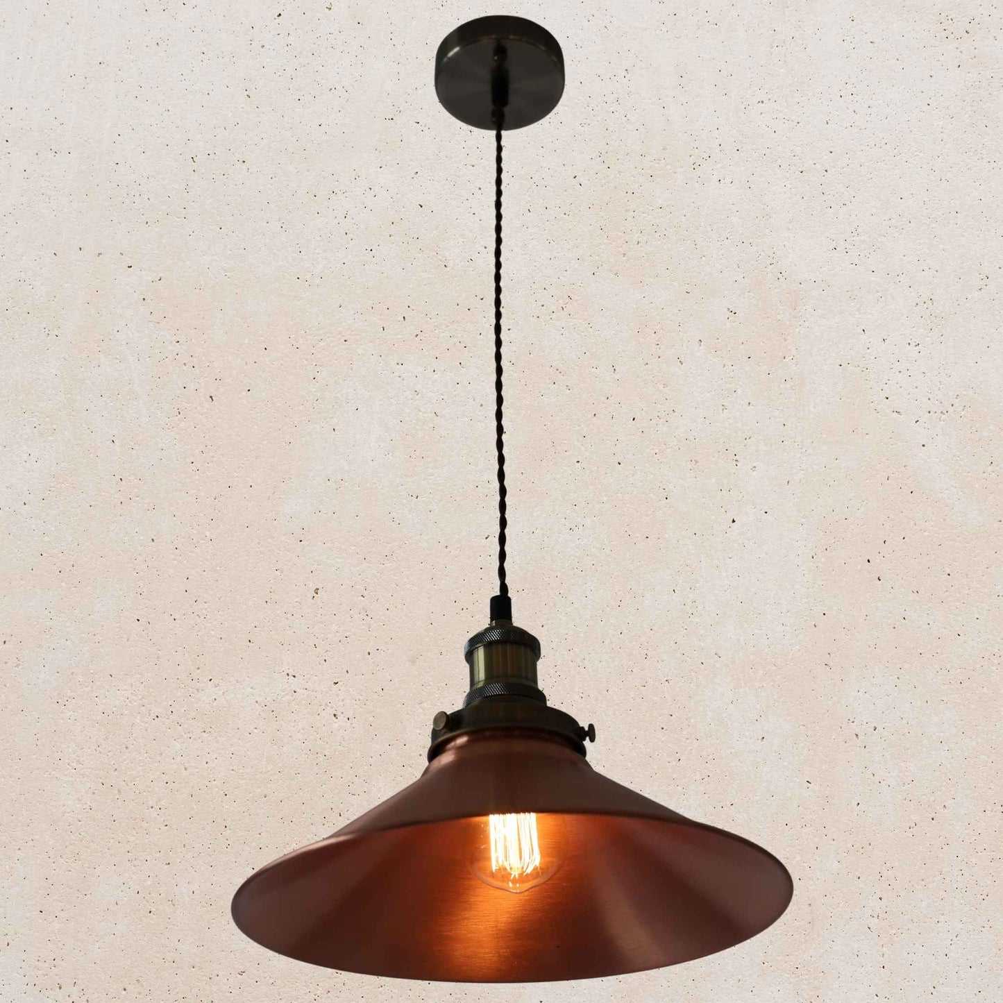 Copper pendant light against a beige textured wall