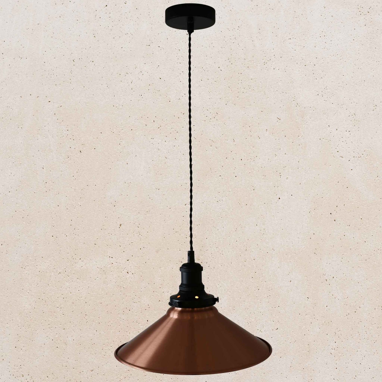 Copper pendant light with black fixture on a beige background