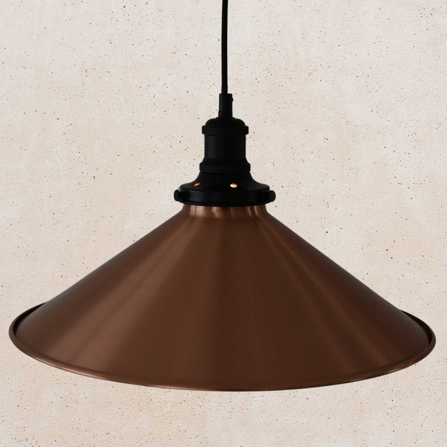 Copper pendant light against a beige wall