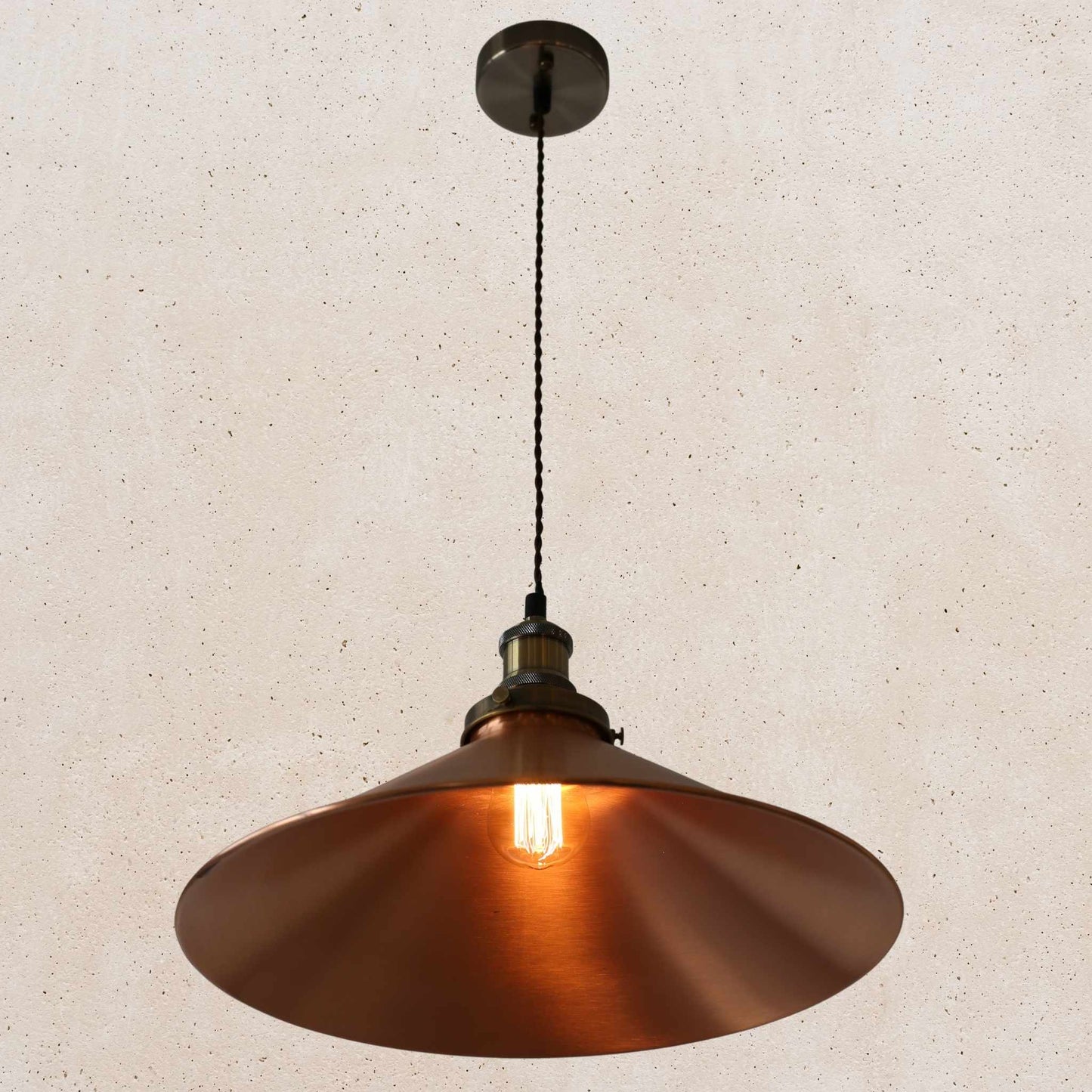 Copper pendant light against a beige wall