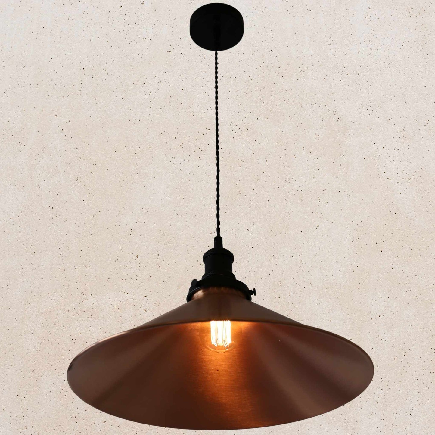 Copper pendant light against a beige wall