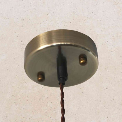 Metallic ceiling rose with cable on a light gray background