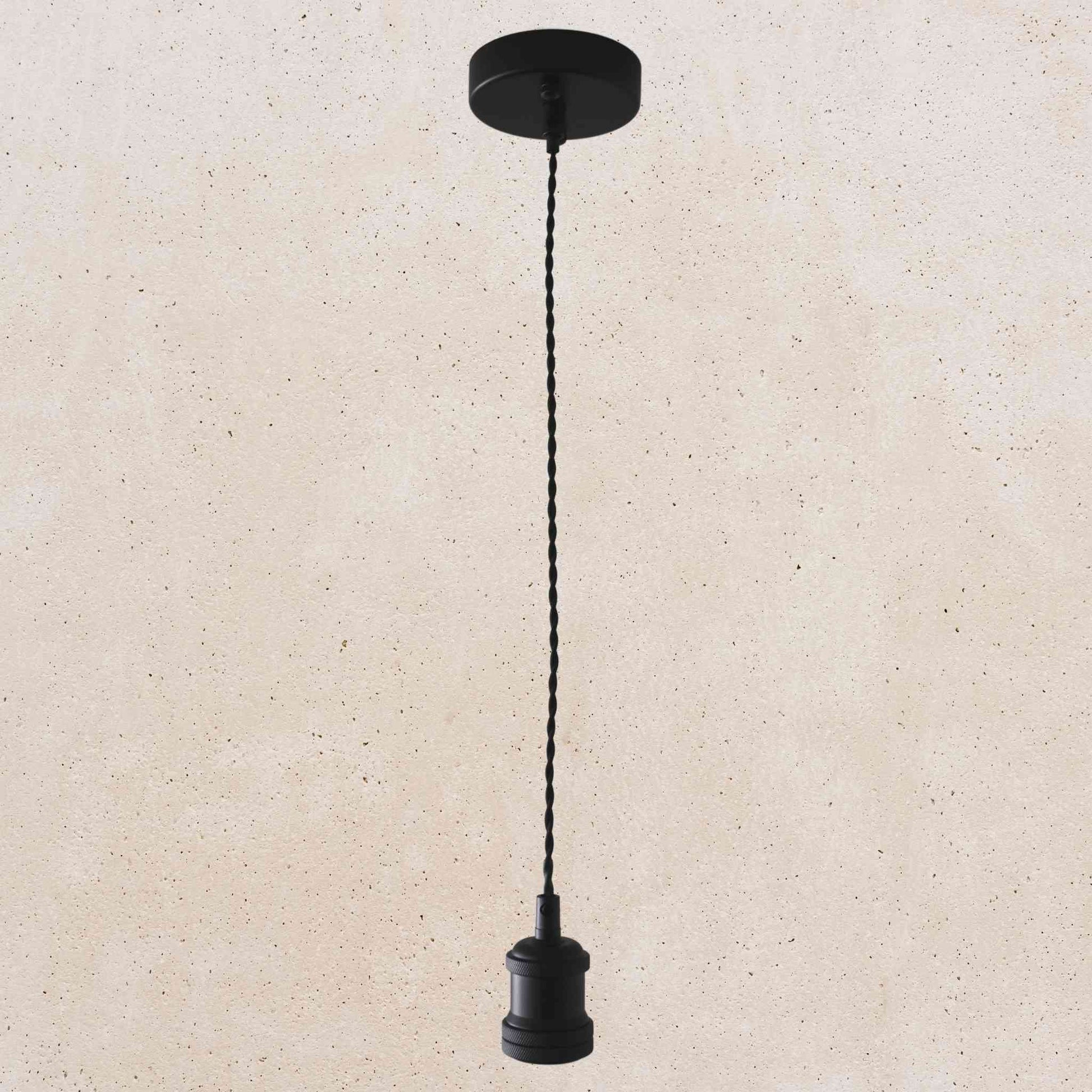Black pendant light with a cord on a beige background