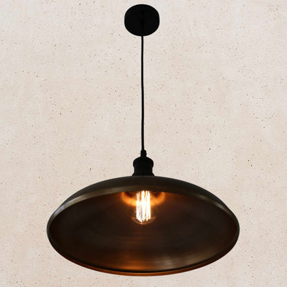 Antique brass pendant light on a beige speckled background
