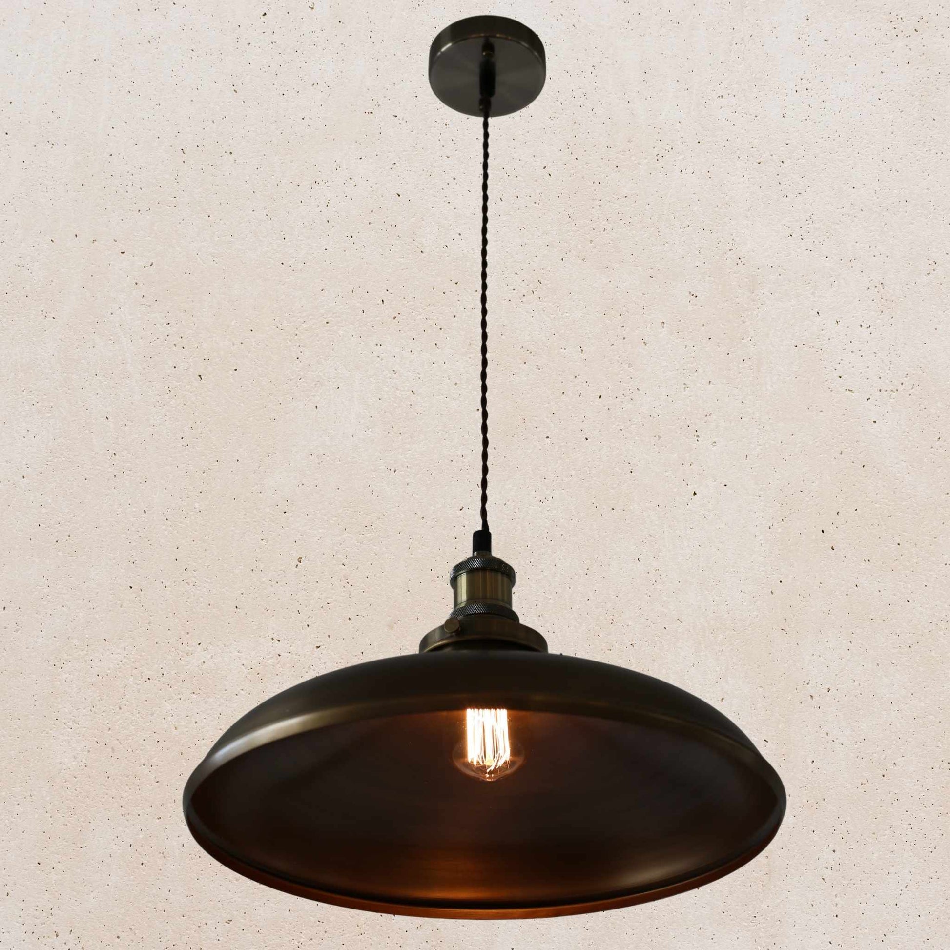 Antique brass pendant light on a beige speckled background