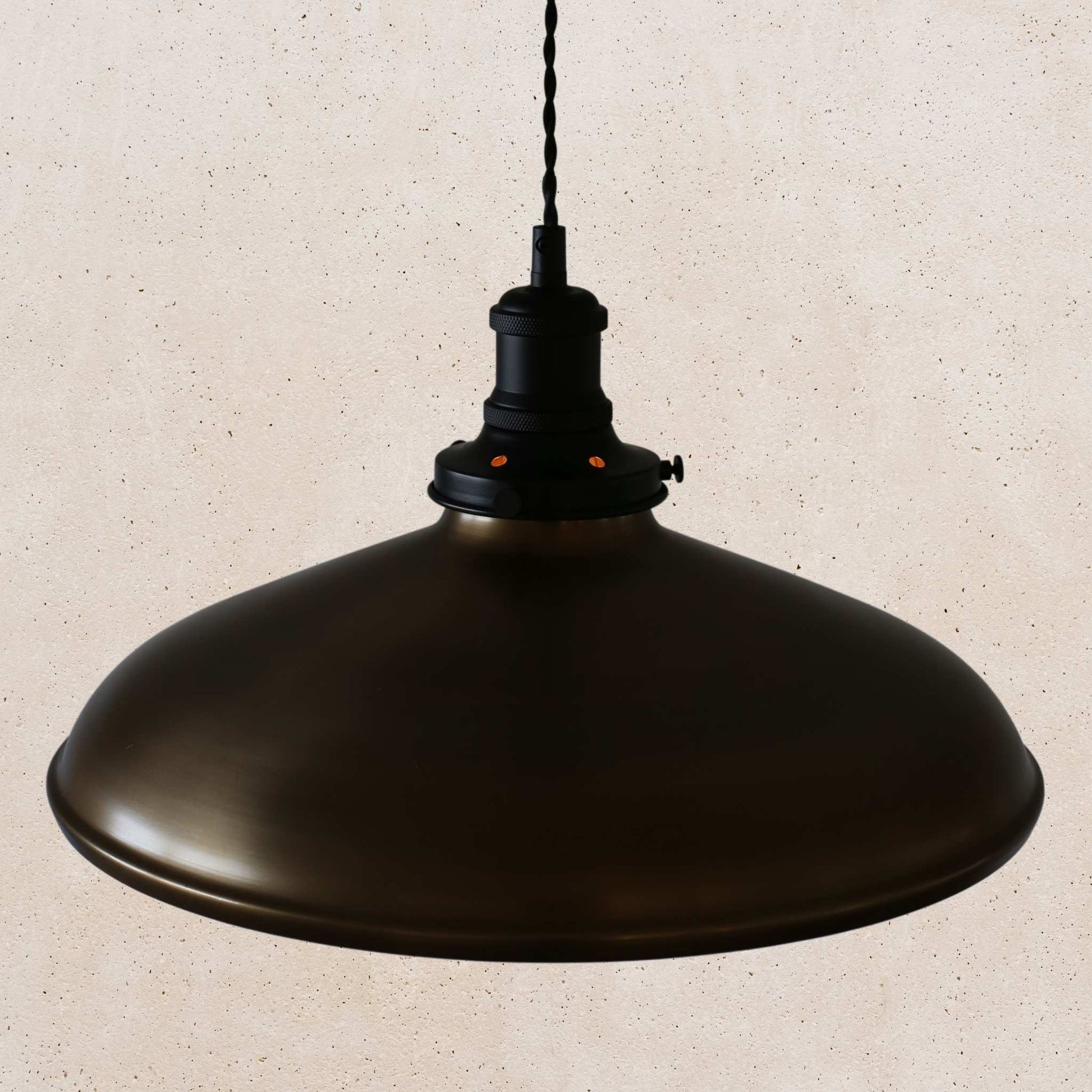 Antique brass pendant light on a beige speckled background