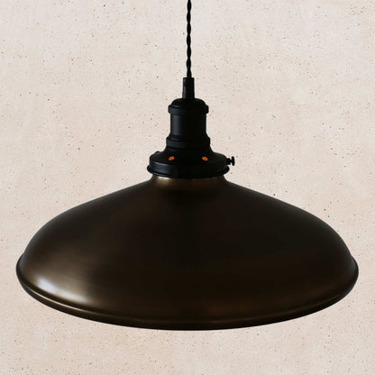 Antique brass pendant light on a beige speckled background