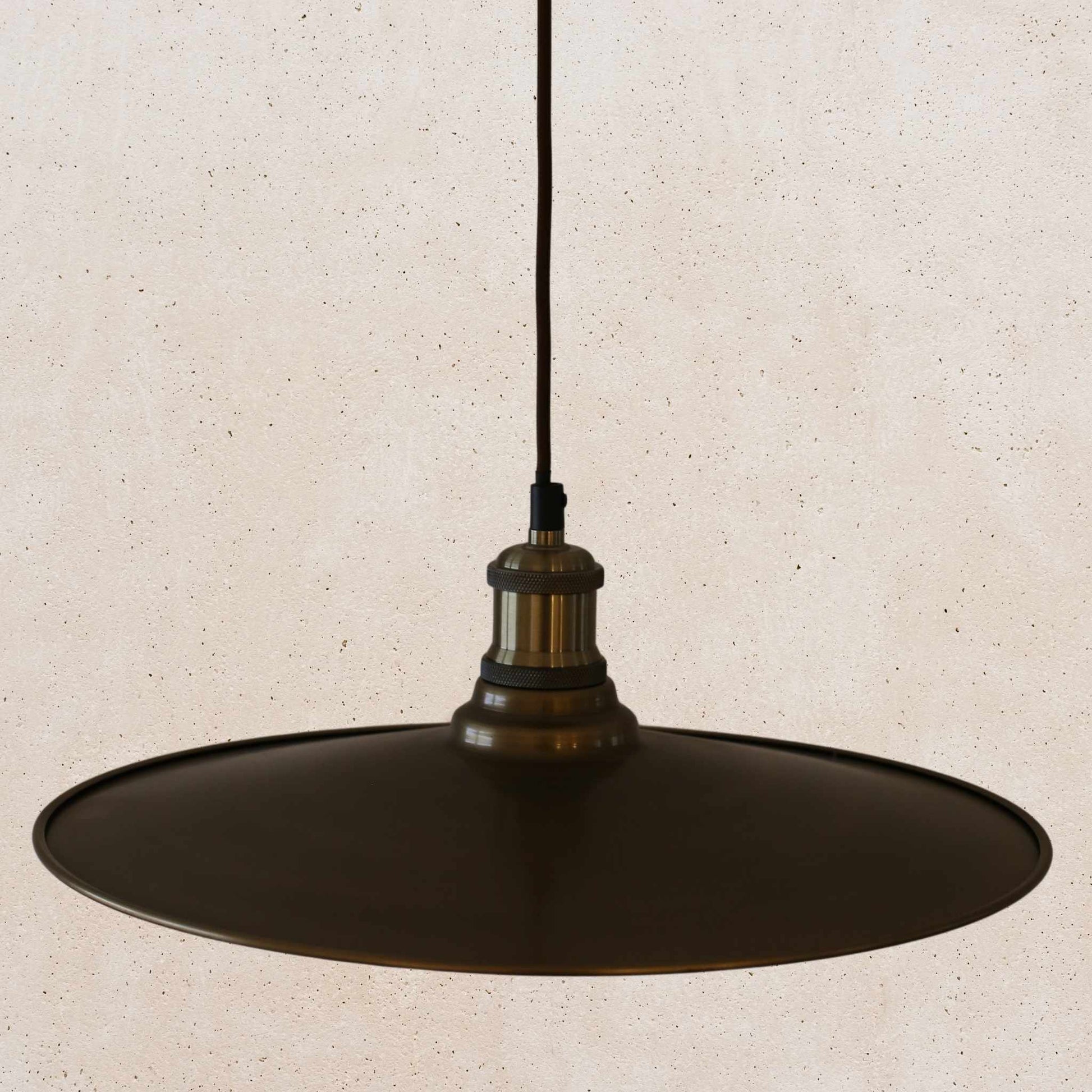 Antique brass pendant light fixture on a beige background