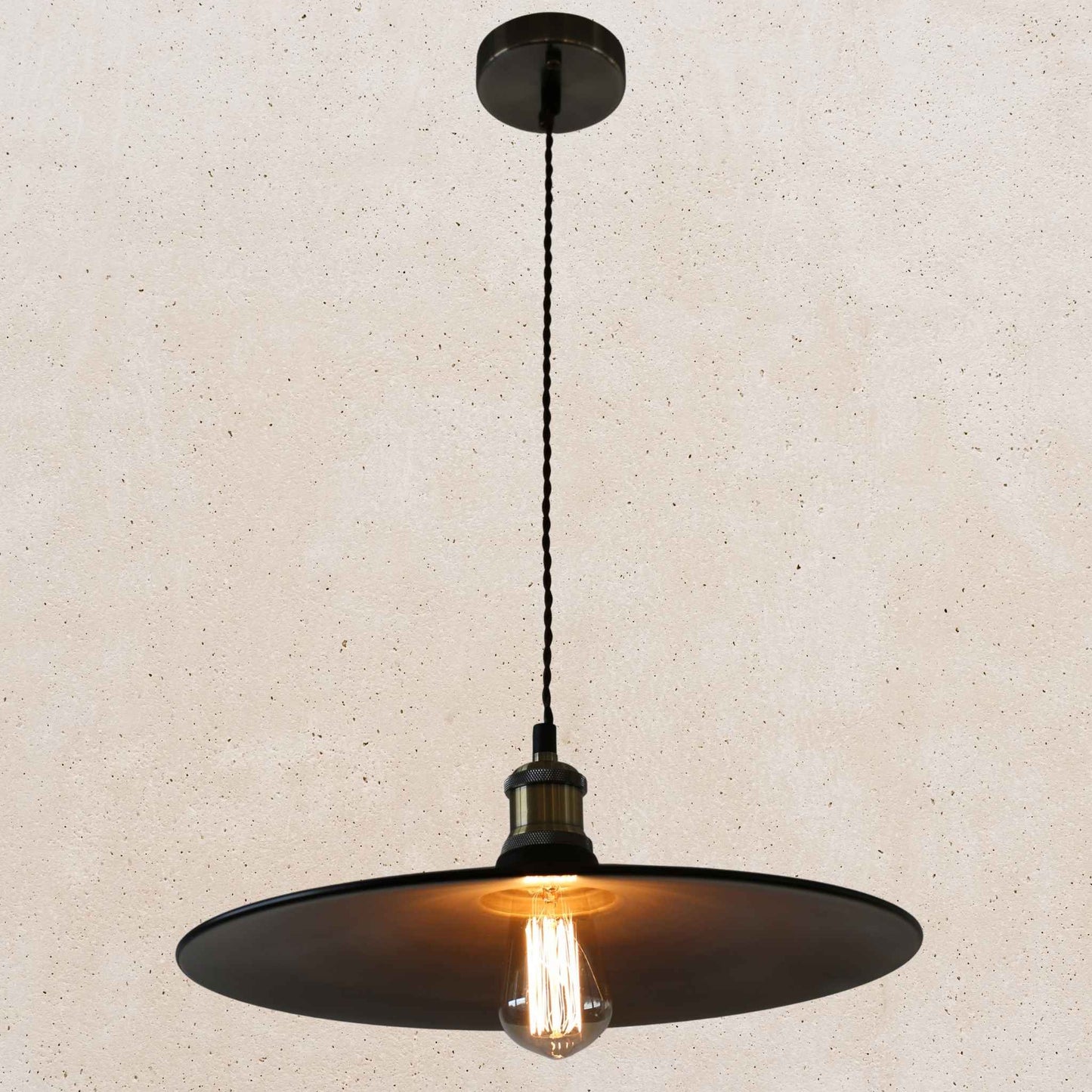 Black pendant light with a visible bulb on a beige background